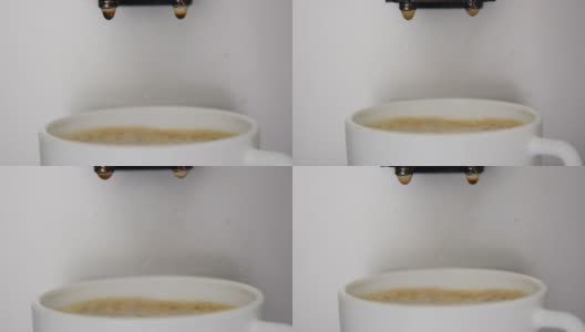 咖啡滴进满杯的白色杯子里，泡沫是棕色的高清在线视频素材下载