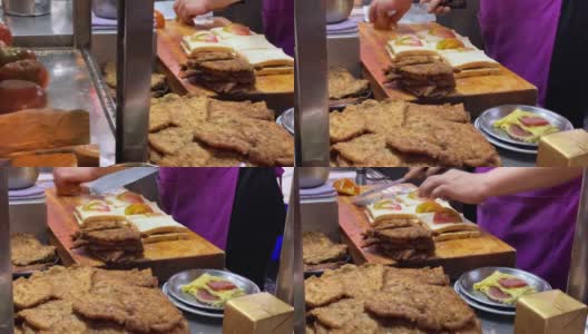 在台湾基隆夜市，厨师正在准备手工炸猪肉三明治高清在线视频素材下载