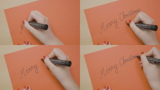 女孩用黑色记号笔在一张红纸卡片上写着圣诞快乐，准备送给她的男朋友高清在线视频素材下载