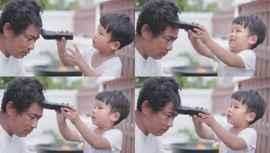 新冠肺炎大流行期间，儿子在家用电动剃须刀给父亲理发高清在线视频素材下载