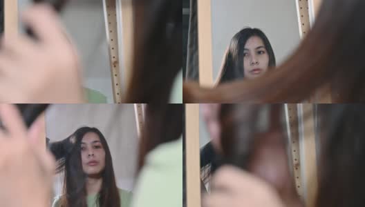 亚洲女子用卷发器卷着头发，时尚地站在镜子前高清在线视频素材下载