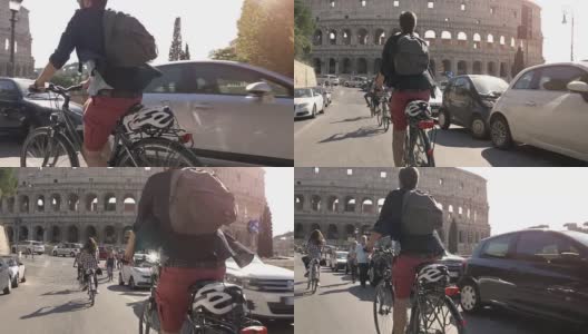 三个年轻的朋友游客在阳光明媚的日子里骑着自行车在罗马市中心的罗马斗牛场周围的道路上慢镜头摄影机汽车稳定摄影机高清在线视频素材下载