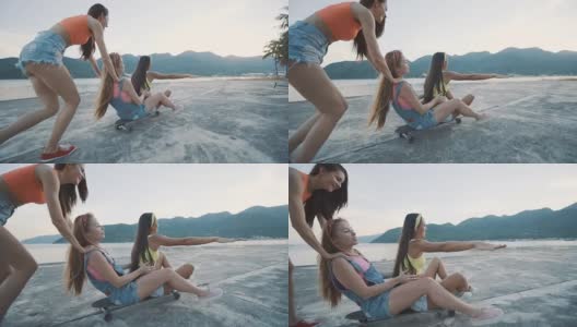 三个朋友，女人微笑着，骑着长板在日落的海滩上。高清在线视频素材下载
