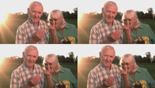 微笑的老夫妇捧着花束。高清在线视频素材下载