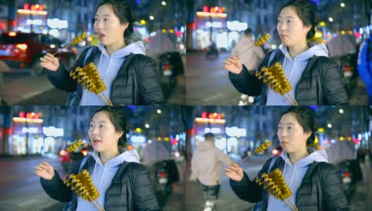 亚洲年轻女子喜欢街头小吃在晚上高清在线视频素材下载