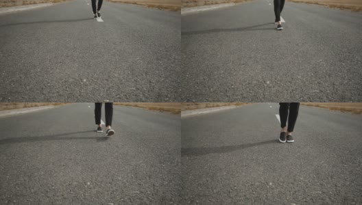 男人的黑色运动鞋与一个白色的鞋底走在灰色的柏油路上一个缓慢，标记的道路高清在线视频素材下载