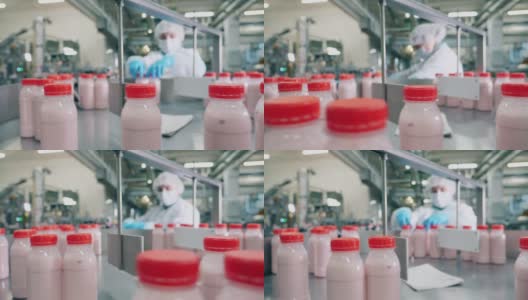 一个在工厂里处理酸奶瓶的人。高清在线视频素材下载