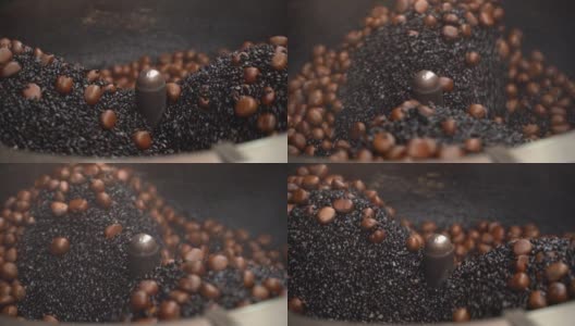 美食视频慢动作沙粒烤栗子场景。把干沙子放进大托盘里，热沙子被加热，这有利于让栗子成熟，4K分辨率的近距离拍摄。高清在线视频素材下载