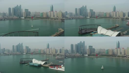 白天青岛市区海岸线海湾纪念碑帆船航行航拍全景4k中国高清在线视频素材下载