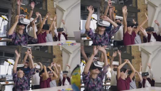 在课堂上，六名学童戴着虚拟现实头盔，举起手臂进行新的编程项目高清在线视频素材下载