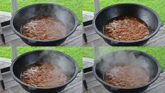 传统的乌兹别克肉饭在一个巨大的锅里炖羊肉，外面有很多蒸汽高清在线视频素材下载