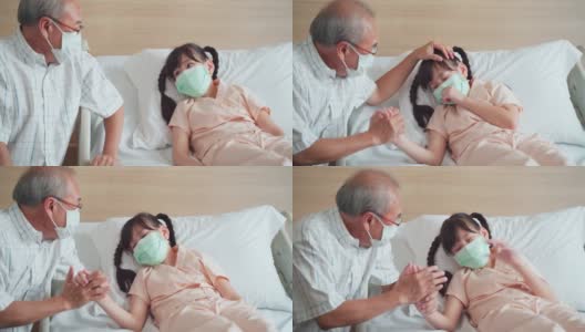 亚洲小女孩戴着口罩躺在康复室的床上，父亲来到康复室探望并照顾她的女儿。高清在线视频素材下载