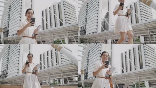 亚洲女性在城市户外行走时用智能手机看屏幕高清在线视频素材下载