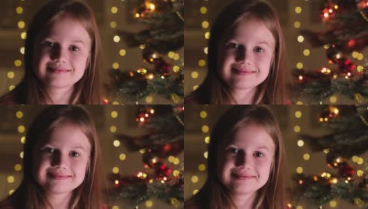 可爱小女孩的肖像，在圣诞树的树枝上，背景是闪闪发光的花环。快乐小孩许下新年愿望，等待圣诞老人和奇迹。快乐的童年高清在线视频素材下载