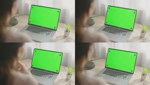 在家里使用带有绿色屏幕的笔记本电脑高清在线视频素材下载