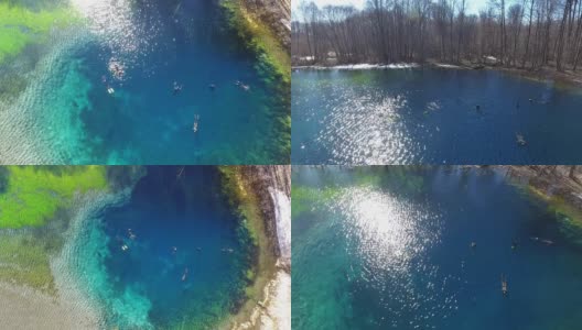 Top view of a clear cold blue lake. Divers in suits swim in clear, clear water. Water with blue minerals aerial view.高清在线视频素材下载