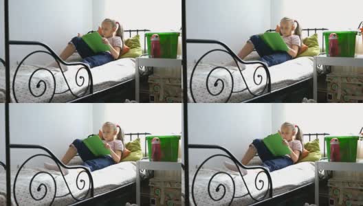 一个金发女孩在家看书的录像高清在线视频素材下载