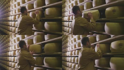 意大利，帕尔马——2018年5月2日——一名奶酪制作者控制着帕尔马奶酪的调味料，这些奶酪必须经过数月的成熟。加工过程遵循古老的意大利传统。高清在线视频素材下载