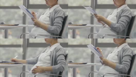 中国怀孕女商人在办公室工作的侧面图高清在线视频素材下载