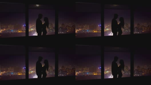 这对情侣站在窗前，背景是夜晚的城市。时间流逝高清在线视频素材下载