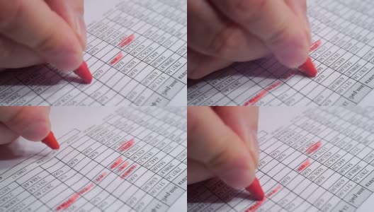 手用红色记号笔在一张写有财务信息的纸上做笔记高清在线视频素材下载
