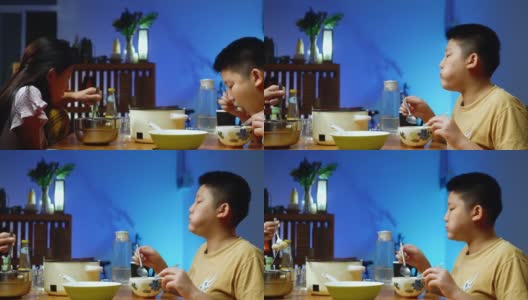 快乐的亚洲男孩吃素喜烧或涮锅，火锅与家人一起搭配食物，Led灯，生活理念。高清在线视频素材下载