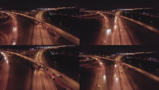 鸟瞰图的立交(交叉)与桥梁和高架桥，高速公路与坡道，繁忙的交通，在夜间。高清在线视频素材下载