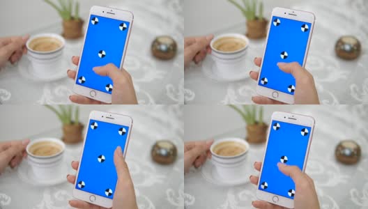 年轻女子，拿着手机，拿着一杯咖啡。(蓝色屏幕)高清在线视频素材下载