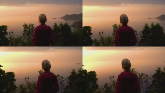 在日落的慢镜头中，科西嘉岛海岸线上的悬崖上的女人和偏远的海滩高清在线视频素材下载
