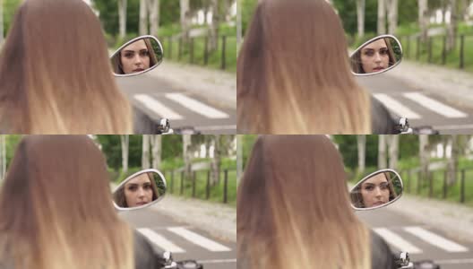女孩在摩托车镜子里的倒影。高清在线视频素材下载