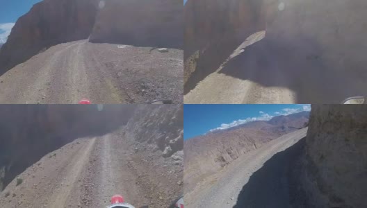 一个骑摩托车的人在一条危险的山路上行驶高清在线视频素材下载