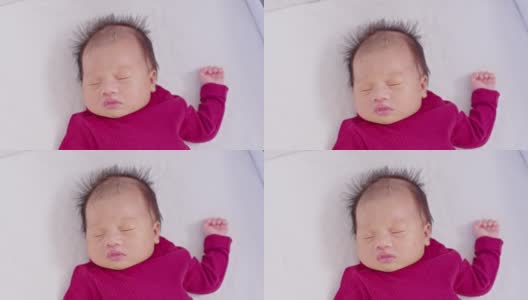 靠近快乐的新生儿躺在白色的毯子上睡觉舒适和安全。可爱的亚洲新生儿在床上睡觉和打盹。新生儿摄影概念高清在线视频素材下载