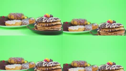 美味的巧克力煎饼和巧克力甜甜圈在绿色屏幕上为派对服务高清在线视频素材下载