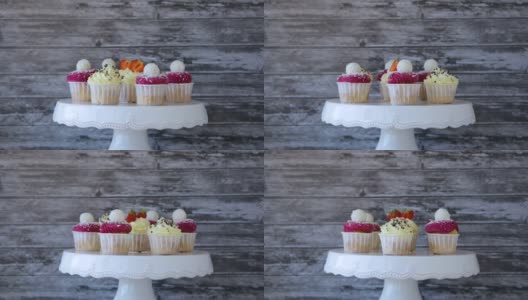 美味的杯形蛋糕，白色的奶油，成熟的草莓，灰蓝色的背景。高清在线视频素材下载