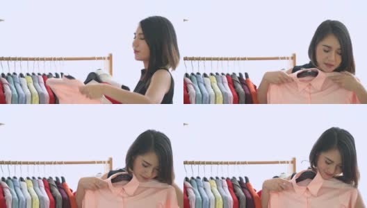 亚洲妇女购物新衣服，选择和试穿新衣服高清在线视频素材下载