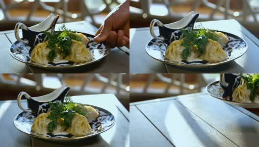 特写:一个人把装有鞑靼饺子的盘子放在桌子上高清在线视频素材下载