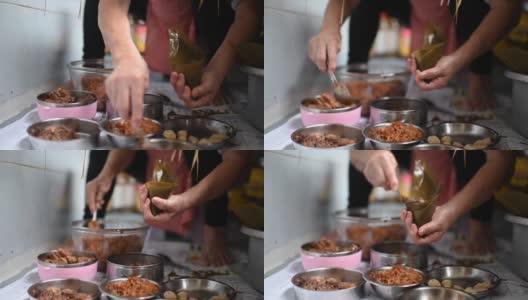一位年长的亚洲华人妇女在她的厨房里准备粽子，把配料包好，为端午节做准备高清在线视频素材下载