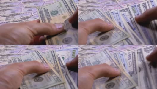 Men's Hands Hold a Pile of American Dollars against the Background of Rotating Money高清在线视频素材下载