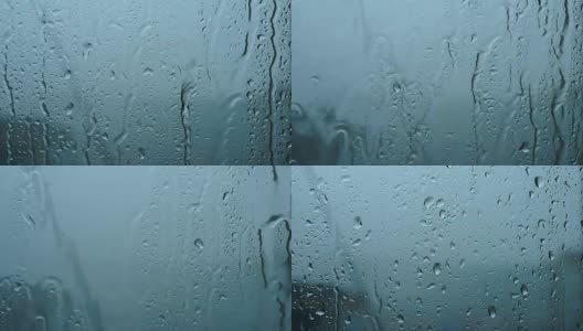一场大雨带着一阵阵大风从窗户里倾泻而出。溪水迅速地从玻璃杯中流下。夏季飓风伴有瓢泼大雨。高清在线视频素材下载