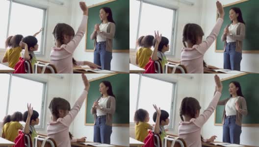 亚洲学校老师与学生举手。在学校工作的年轻女子举起手臂，学校的孩子们举起双手回答问题，热情、渴望、享受高清在线视频素材下载