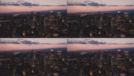 黄昏时分，俯瞰金融中心金丝雀码头的现代高层建筑。从高处照亮了夜城。英国伦敦高清在线视频素材下载