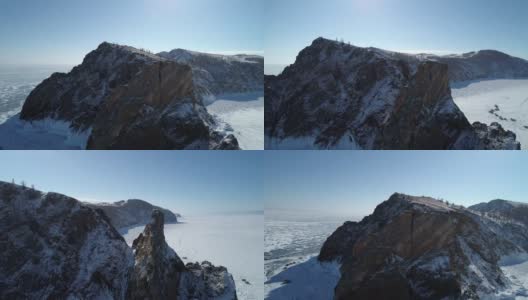 空中轨道拍摄的霍博伊角，奥尔洪岛。结冰的贝加尔湖上高耸的岩石，周围有许多人和汽车。受欢迎的旅游目的地。冬天的风景。全景高清在线视频素材下载