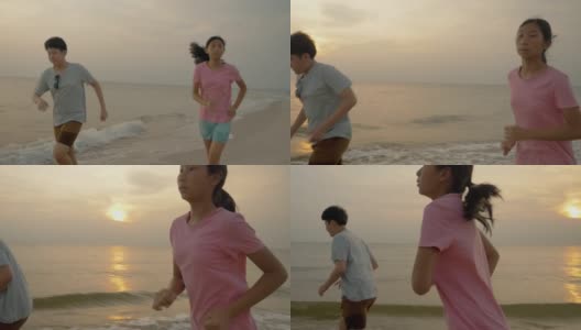 亚洲儿童在沙滩上奔跑，伴以日出为背景，积极的生活理念。高清在线视频素材下载