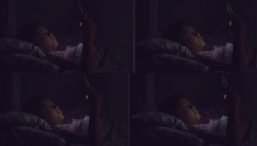 一个可爱的小女孩在床上用平板电脑的多莉幻灯片高清在线视频素材下载
