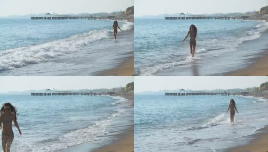 年轻美丽的皮肤黝黑的女人，长头发的比基尼在沙滩上跑步高清在线视频素材下载
