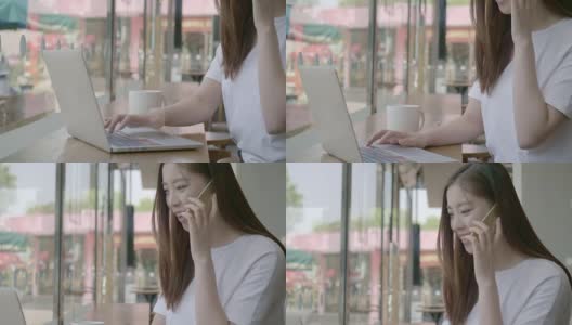 亚洲年轻女子在一个咖啡馆打电话，看着她的笔记本电脑屏幕在她的咖啡休息时间高清在线视频素材下载