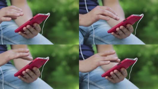 男人在智能手机上看照片。男人拿着红色的手机高清在线视频素材下载