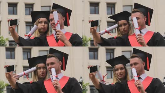 滑稽的学生穿着学术服在手机上自拍，毕业典礼高清在线视频素材下载
