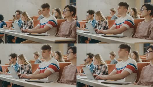 英俊的白人学生在大学听讲座时使用笔记本电脑。多元民族的现代聪明学生投资他们的未来。高清在线视频素材下载