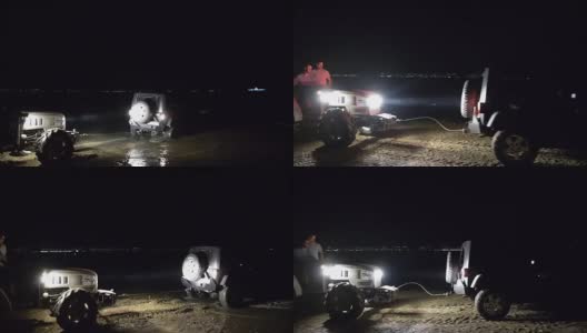 一辆大拖拉机从沼泽里拖出来一辆吉普车。高清在线视频素材下载